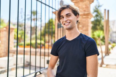 Young caucasian man smiling confident standing at street