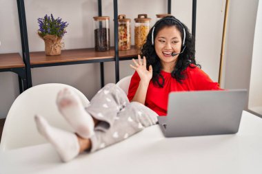 Young chinese woman operator having video call at home