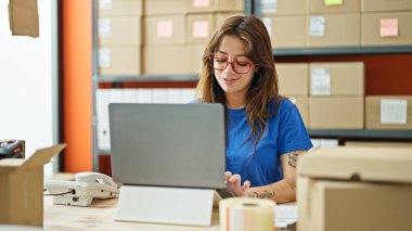 Young beautiful hispanic woman ecommerce business worker using laptop working at office