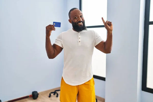 Hombre Afroamericano Usando Ropa Deportiva Sosteniendo Tarjeta Crédito Sonriendo Con —  Fotos de Stock