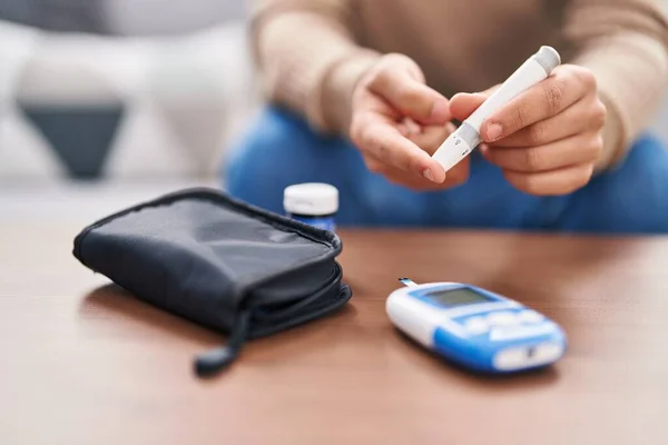 stock image Young non binary man measuring glucose at home