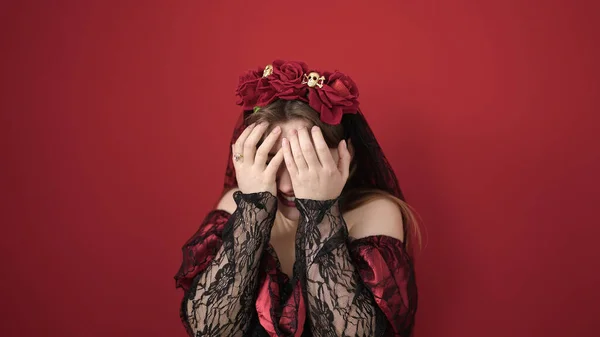 年轻的金发女子 身穿卡特里娜服装 双手捂住孤立的红色背景 满脸通红 — 图库照片