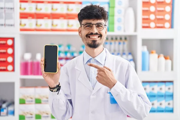 Young Hispanic Man Beard Working Pharmacy Drugstore Showing Smartphone Screen — Stock Photo, Image