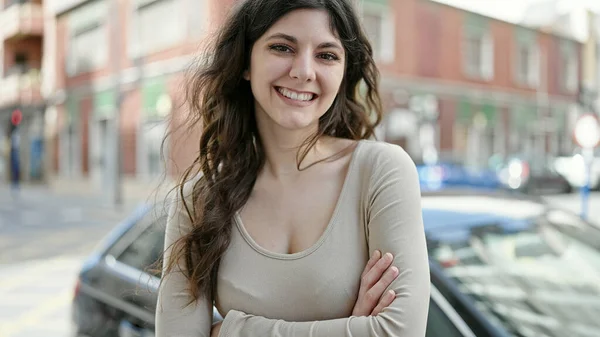 年轻美丽的惊慌失措的女人微笑着 自信地站在街头 双手交叉地摆出姿势 — 图库照片