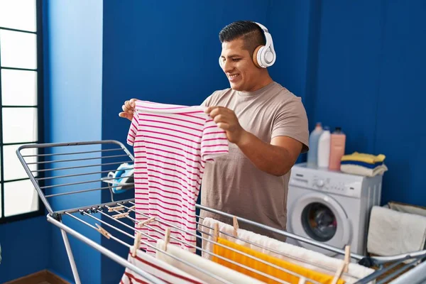 Mladý Latinský Muž Poslouchá Hudbu Visí Oblečení Prádelní Šňůře Prádelně — Stock fotografie