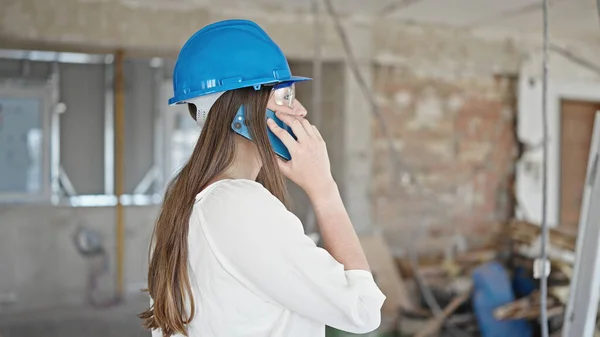 年轻美丽的惊慌失措的女建筑商在建筑工地用智能手机交谈 — 图库照片