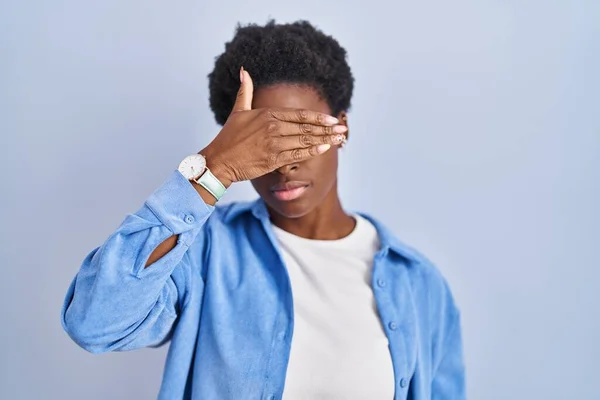 Αφροαμερικανή Που Στέκεται Πάνω Από Μπλε Φόντο Καλύπτοντας Μάτια Χέρι — Φωτογραφία Αρχείου
