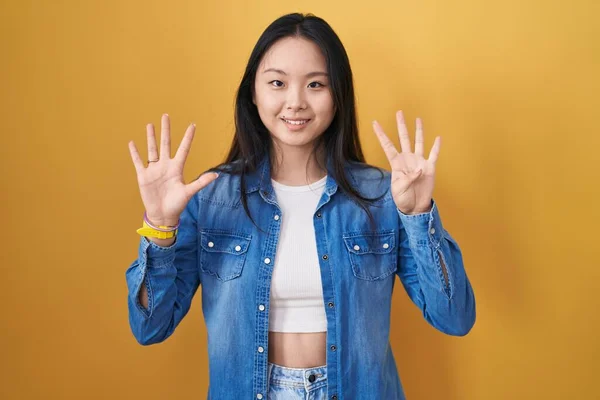 Młoda Azjatycka Kobieta Stojąca Nad Żółtym Tle Pokazując Wskazując Palcami — Zdjęcie stockowe