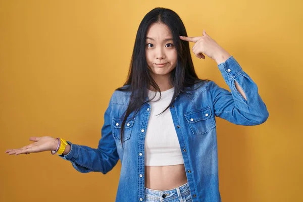 Młoda Azjatka Stojąca Nad Żółtym Tłem Zdezorientowana Zirytowana Otwartą Dłonią — Zdjęcie stockowe