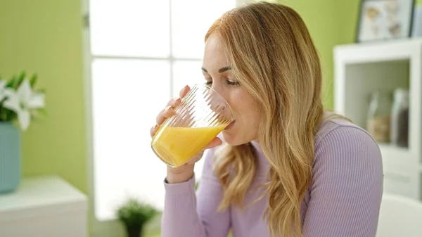 年轻美丽的惊慌失措的女人在饭厅里喝果汁 — 图库照片