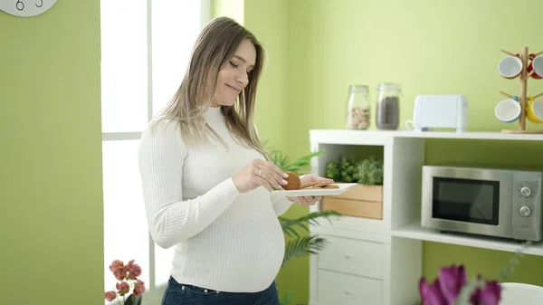 Ung Gravid Kvinna Äter Kakor Stående Matsalen — Stockfoto