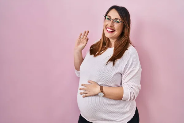 Gravid Kvinna Som Står Över Rosa Bakgrund Ler Positivt Gör — Stockfoto