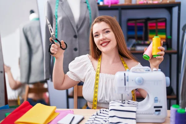 Young Redhead Woman Tailor Smiling Confident Holding Scissors Thread Clothing — 图库照片