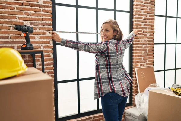 Young Blonde Woman Smiling Confident Measuring Window New Home — Fotografia de Stock