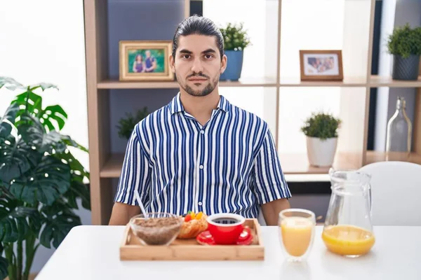 Spaanse Man Met Lang Haar Tafel Ontbijten Met Serieuze Uitdrukking — Stockfoto