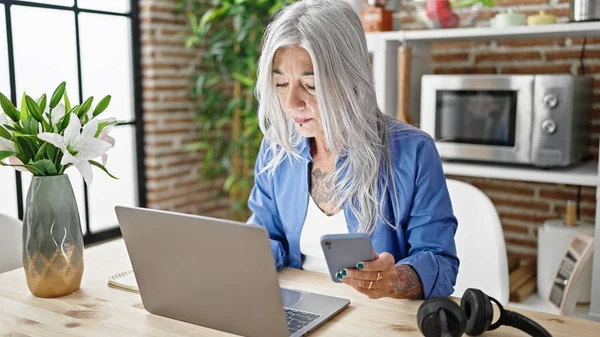 Středního Věku Šedovlasá Žena Pomocí Notebooku Smartphonu Sedí Stole Jídelně — Stock fotografie
