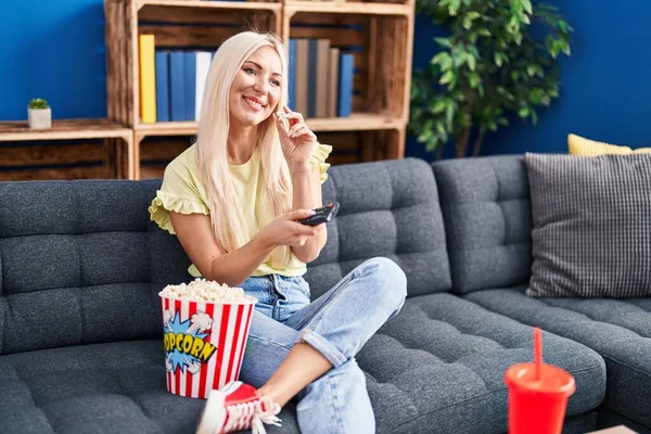 Young Blonde Woman Watching Movie Sitting Sofa Home — Stockfoto