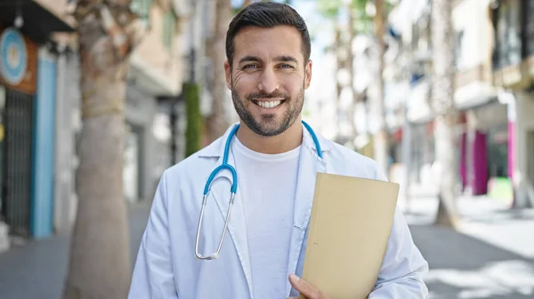 Junger Hispanischer Arzt Lächelt Zuversichtlich Und Hält Medizinischen Bericht Auf — Stockfoto