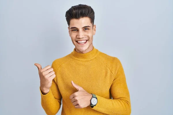 Young Hispanic Man Standing Blue Background Pointing Back Hand Thumbs — Foto de Stock
