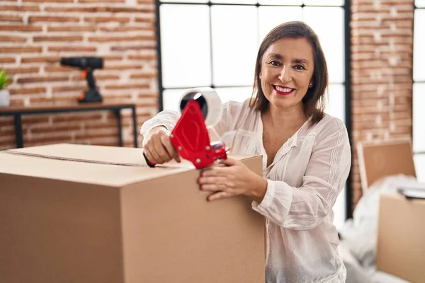 Middle Age Woman Smiling Confident Packing Cardboard Box New Home — ストック写真