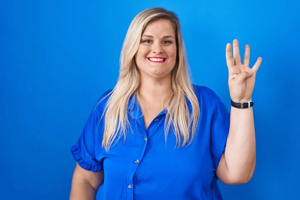 白种人加其他身材的女人站在蓝色的背景上 带着自信和快乐的笑容 指指点着四号手指 — 图库照片