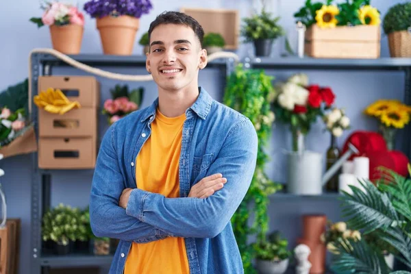Young hispanic man florist smiling confident standing with arms crossed gesture at florist store