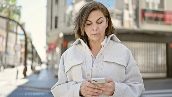 中年惊慌失措的女人在街上用智能手机 — 图库照片