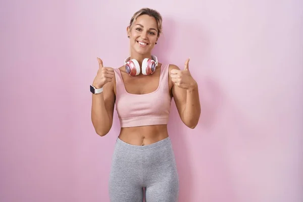 Young Blonde Woman Wearing Sportswear Headphones Success Sign Doing Positive — Stock Photo, Image