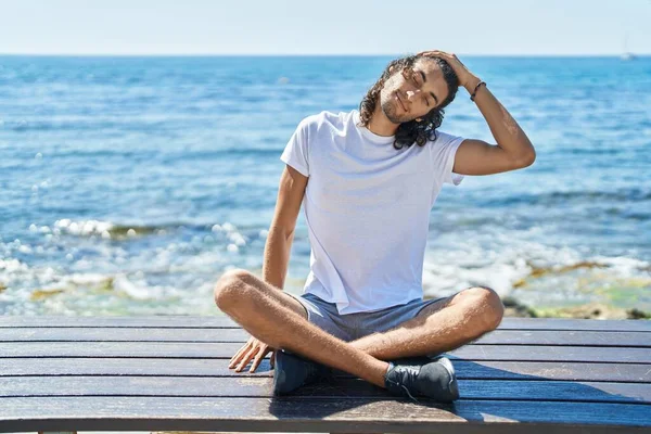 Young Hispanic Man Doing Yoga Exercise Sitting Bench Seaside — Stockfoto
