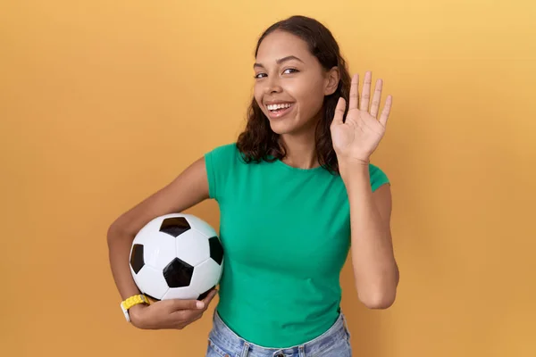 Young Hispanic Woman Holding Ball Waiving Saying Hello Happy Smiling — Stock Photo, Image