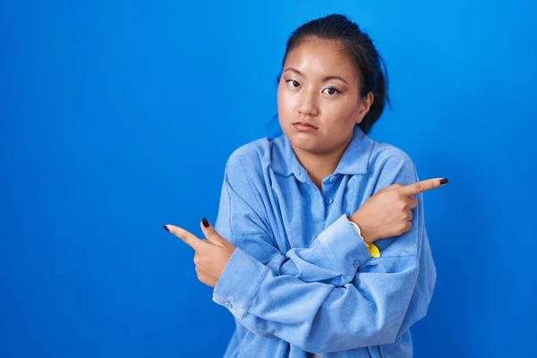 Asian Young Woman Standing Blue Background Pointing Both Sides Fingers — Stock Photo, Image