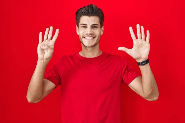 Kırmızı Arka Planda Duran Spanyol Genç Adam Dokuz Numaralı Parmaklarını — Stok fotoğraf