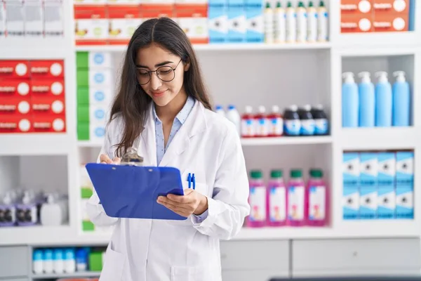 Young Hispanic Girl Pharmacist Writing Report Clipboard Pharmacy — 스톡 사진