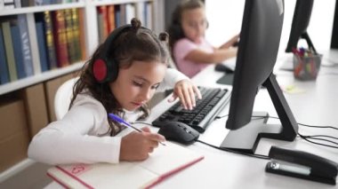 Sınıfta bilgisayar kullanarak notlar alan sevimli kızlar.