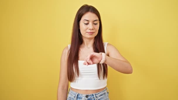 Młoda Piękna Latynoska Kobieta Patrząc Zegarek Ekspresją Zaskoczenia Odizolowanym Żółtym — Wideo stockowe