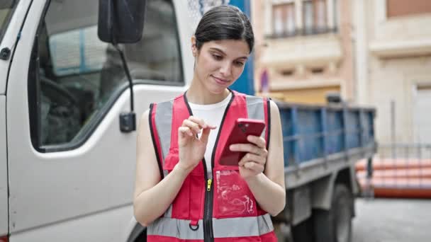 年轻美丽的惊慌失措的女人用智能手机站在街上的卡车旁 — 图库视频影像
