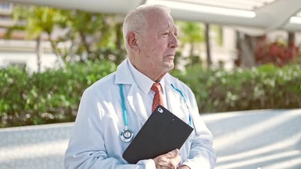Senior Gris Pelo Hombre Médico Sonriendo Confiado Sosteniendo Touchpad Parque — Vídeo de stock