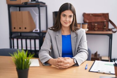 Genç ve güzel İspanyol iş kadını. Ofiste masasında kendinden emin bir şekilde oturuyor.