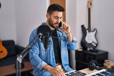 Genç İspanyol ressam gülümsüyor. Müzik stüdyosundaki akıllı telefondan konuşuyor.