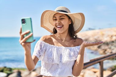 Genç Brezilyalı bir kadın akıllı telefonuyla fotoğraf çekiyor. Gururla bağırıyor, zaferi kutluyor ve kollarını kaldırarak başarıyı kutluyor. 