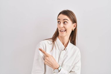 Young caucasian woman standing over isolated background pointing aside worried and nervous with forefinger, concerned and surprised expression 