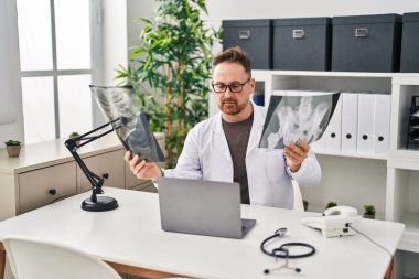Kafkasyalı genç bir doktor klinikteki masada oturuyor.