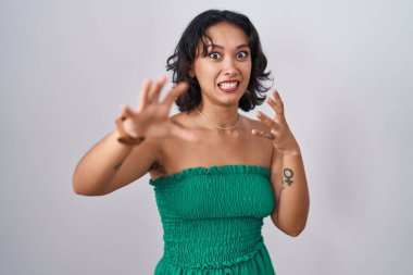 Soyutlanmış arka planda duran genç İspanyol kadın korku ifadesinden korkuyor ve dehşete düşüyor. El hareketlerini durdur, şok içinde bağır. panik konsepti. 