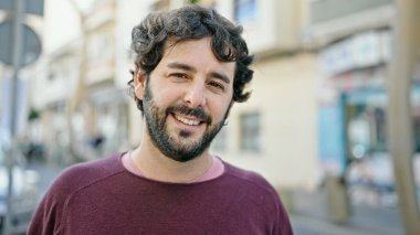 Sokakta kendinden emin gülümseyen İspanyol genç adam.