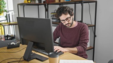 Young hispanic man business worker using computer working at office