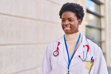 Sokakta dikilen doktor üniforması giyen Afrikalı Amerikalı kadın.