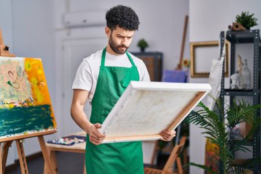 Sanat stüdyosundaki Arap adam şüpheci ve gergin, sorun yüzünden surat asıyor. negatif kişi. 