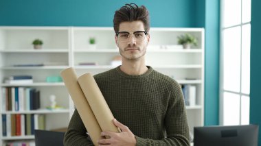 Genç İspanyol öğrenci kütüphane üniversitesinin planlarını tutuyor.