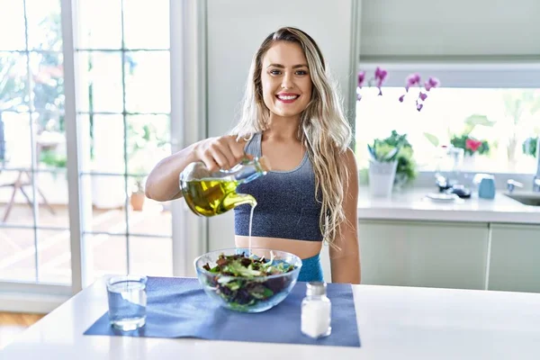 Junge Frau Lächelt Selbstbewusst Und Gießt Küche Auf Salat — Stockfoto