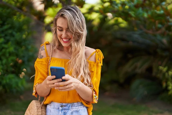 Νεαρή Γυναίκα Χαμογελά Αυτοπεποίθηση Χρησιμοποιώντας Smartphone Στο Πάρκο — Φωτογραφία Αρχείου